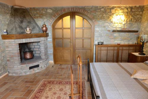 een slaapkamer met een stenen open haard en een houten deur bij Torretta di Bassano in Rivergaro