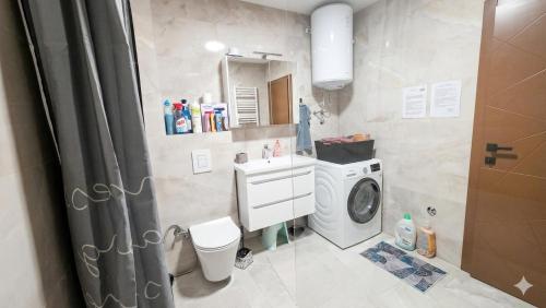 a bathroom with a washing machine and a washer at Apartment Real in Bugojno