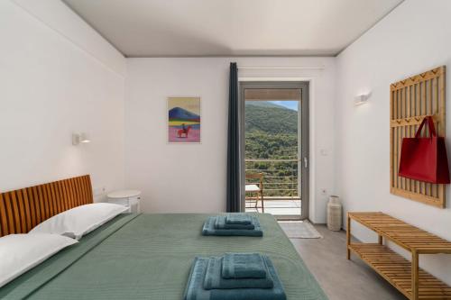 a bedroom with a large bed and a balcony at Mediterra Messinia in Kalamata