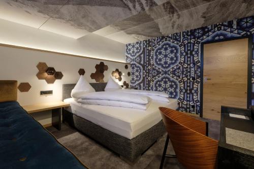 a bedroom with a king sized bed and a desk at Boutique Hotel Gams in Oberstdorf