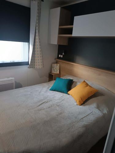 a bedroom with a bed with two pillows on it at Lesoleil in Canet-en-Roussillon