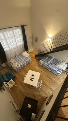 a room with two bunk beds and a table and chairs at Centro Storico Caruggi 2min Acquario Pellicceria Superior Loft Palazzo Rolli in Genoa