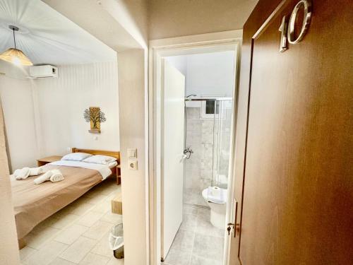 a small bedroom with a bed and a shower at Aetherion in Agios Ioannis Pelio