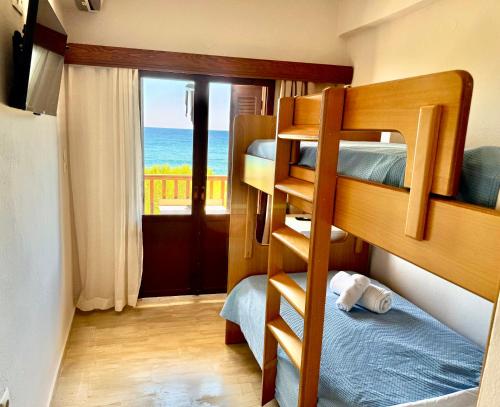 a bedroom with bunk beds with a view of the ocean at Aetherion in Agios Ioannis Pelio