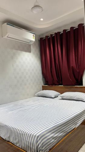 a bedroom with a bed with a red curtain at Universal Inn in Chennai