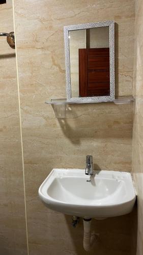 a bathroom with a sink and a mirror at Universal Inn in Chennai