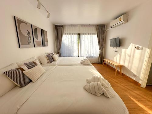 a large white bedroom with two beds in it at Link Mansion in Chiang Mai