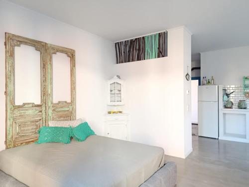 ein weißes Schlafzimmer mit einem Bett mit blauen Kissen in der Unterkunft Hellas4ever in Chrysoupolis