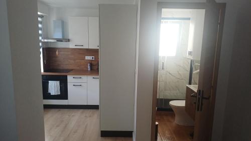 a kitchen with white cabinets and a toilet at Appartement lena in Boulogne-sur-Mer