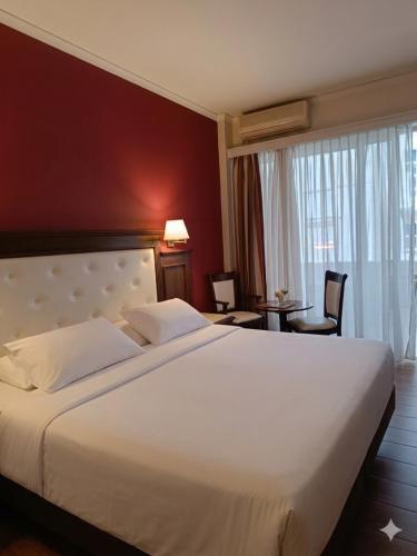 a bedroom with a large white bed in a room at Achillion Palace Hotel Rethymno City Center in Rethymno