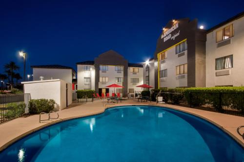 a pool in front of a hotel at night at Super 8 by Wyndham Mesa Gilbert in Mesa