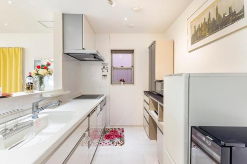 a white kitchen with a sink and a refrigerator at nonon in Osaka