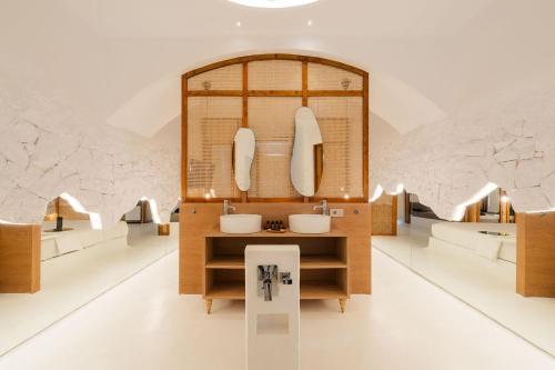 a bathroom with sinks and mirrors in a room at Anome Experience Hotel in Ornos