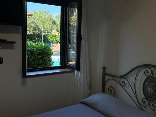 a bedroom with a bed and a window at Tenuta Ciaramiti Luxury Garden & Pool in Brattirò