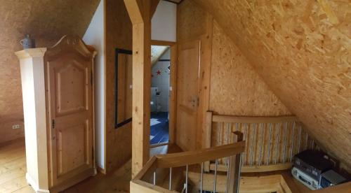 an attic room with a staircase in a house at Ferienunterkünfte Deinhardt in Poxdorf