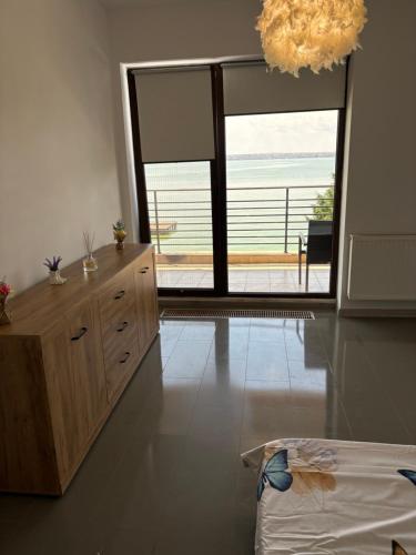 a bedroom with a large sliding glass door with a view of the ocean at Apartament Summerland Mamaia Nord in Mamaia