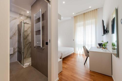 a bathroom with a shower and a bed and a desk at Lumen Boutique Stay in Naples