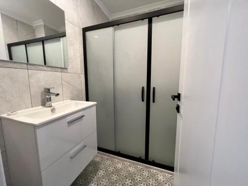 a white bathroom with a sink and a mirror at Dada Otel in Ezine