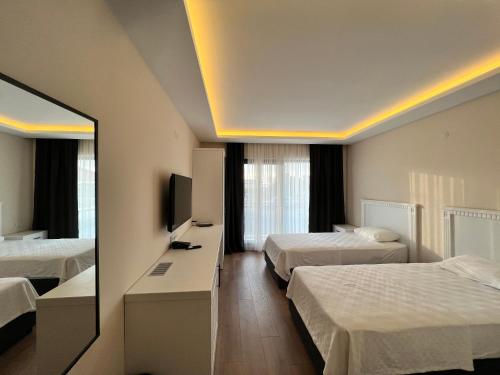 a hotel room with two beds and a mirror at Dada Otel in Ezine