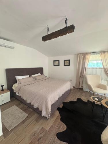 a bedroom with a large bed and a chair at Danguba 5 in Nova Pazova