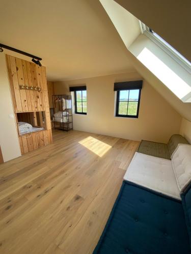an attic room with a vaulted ceilings and wooden floors at Villa Cdv in Ellezelles