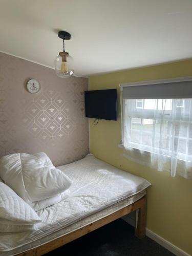 a bed in a room with a window at Sheppey Village Roxy in Leysdown-on-Sea