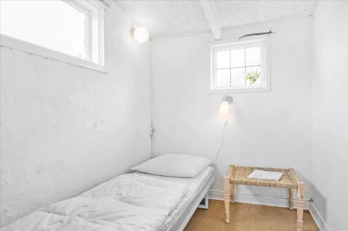 a small white room with a bed and a table at 30001-Malling-Hasselvaenget-7 in Malling