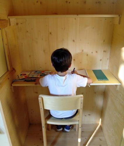 a young boy sitting at a desk with a book at Villa delle rose Brisighella in Brisighella