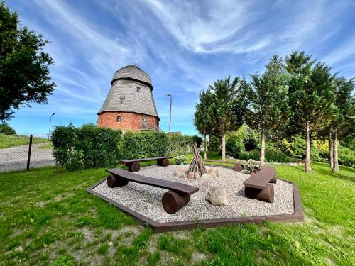 a park with benches and a building in the background at Apartament Pod Wiatrakiem in Bęsia