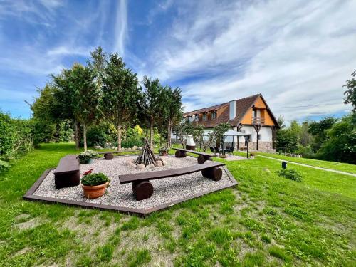 a backyard with a bench and a house at Apartament Pod Wiatrakiem in Bęsia