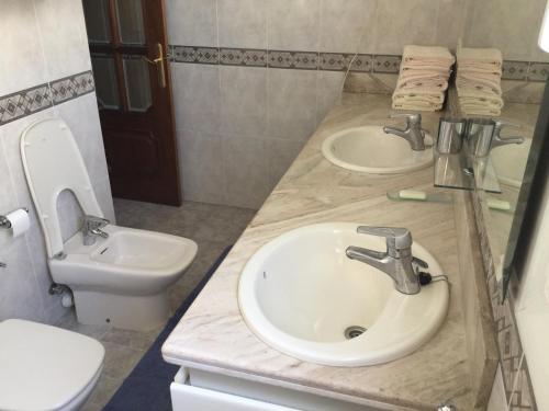 a bathroom with two sinks and a toilet at Al Centre Del Port in Cambrils