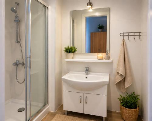 a white bathroom with a sink and a shower at Admiral aqua resort in Mielno