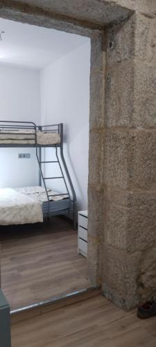 a room with a bed and a brick wall at O rincón do Mimo in Ribeira