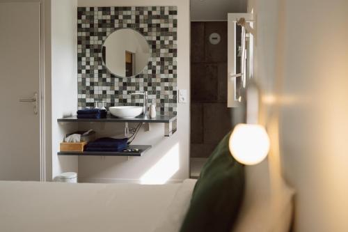 a bathroom with a sink and a mirror at LA DOLOREANNE in Saint-Didier-sur-Chalaronne