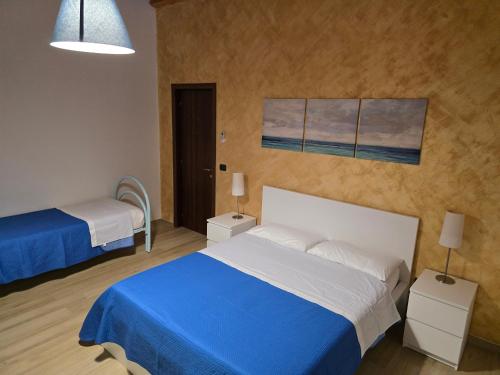 a bedroom with two beds and a painting on the wall at Lemon House in Avola
