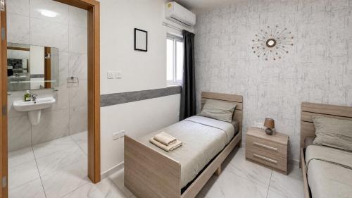 a small bedroom with a bed and a bathroom at Arzella Apartments Xlendi, Premium 2BR, Bus Stop & Market Opposite in Xlendi