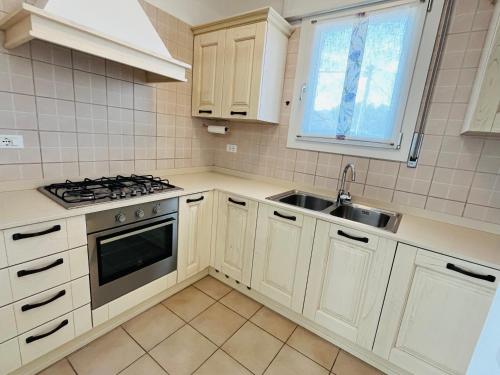 a kitchen with white cabinets and a sink at La casa di Teo in Cappella Maggiore