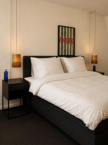 ein Schlafzimmer mit einem großen Bett mit weißer Bettwäsche in der Unterkunft La Rive in Enschede