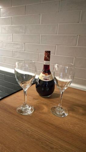 two wine glasses and a bottle on a table at Veronica's House in Zagora