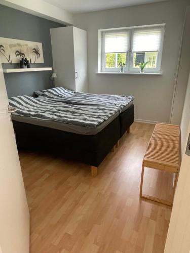 ein großes Bett in einem Zimmer mit Holzboden in der Unterkunft Bogense strand in Bogense