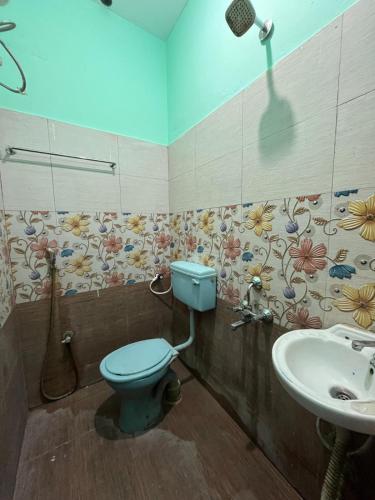 a bathroom with a blue toilet and a sink at Gravity Groups Core - Star residency in Pondicherry