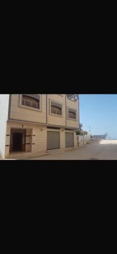 a building with two garage doors on a street at Ajdir in Ajdir