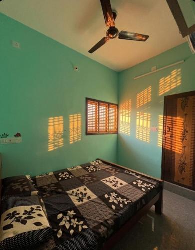 a bed in a room with a ceiling fan at Gravity Groups Core - Star residency in Pondicherry