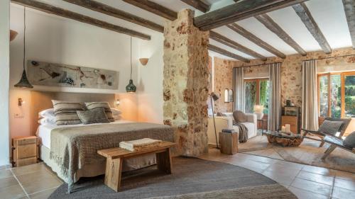 a bedroom with a bed and a table in a room at Agroturismo Son Fogueró - Adults Only in Maria de la Salut
