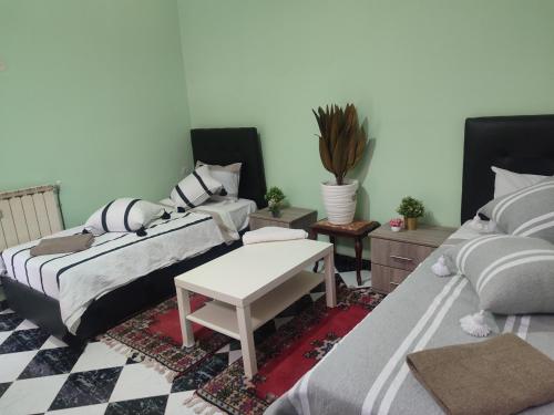 a living room with two beds and a table at Ryad dar midelt in Midelt