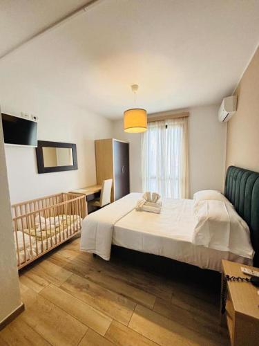 a bedroom with a large white bed and a couch at Hotel Virginia in Marina di Massa