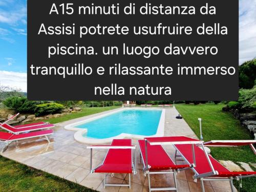 a villa with a swimming pool and red chairs at Suite Assisi in Assisi