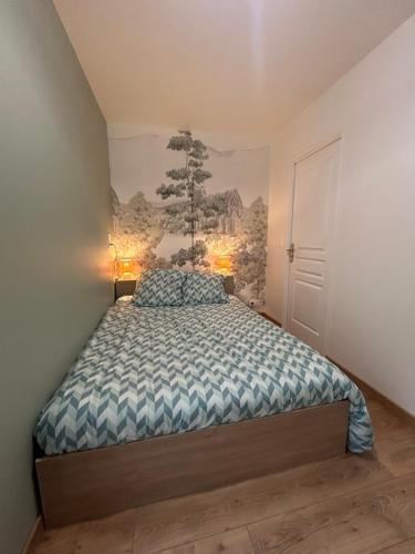 a bedroom with a bed and a painting on the wall at Le refuge des coteaux in Trelou Sur Marne