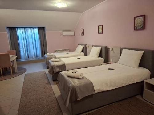 a hotel room with two beds and a couch at SOBE Svilajnac in Svilajnac