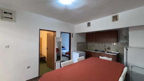 a kitchen with a table and a kitchen with a refrigerator at Private guest-house Gutic in Sutomore